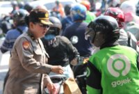 Polwan Polrestabes Surabaya berbagi helm dan bunga