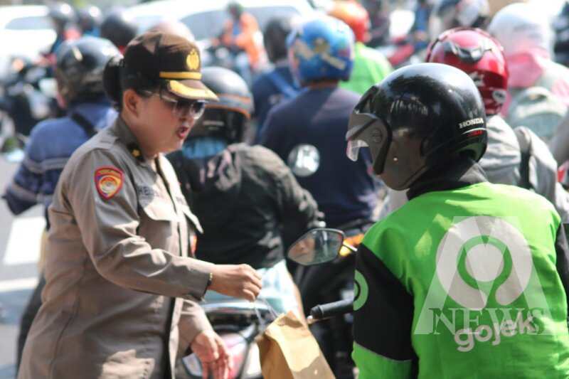 Polwan Polrestabes Surabaya berbagi helm dan bunga