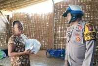 Bhabinkamtibmas Polsek Curahdami Aiptu Ahmad Abadi bagi sembako ke warga