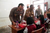 Kapolres Malang AKBP Putu Kholis Aryana bagi makanan ke SDN 4 Sitiarjo