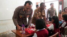 Kapolres Malang AKBP Putu Kholis Aryana bagi makanan ke SDN 4 Sitiarjo