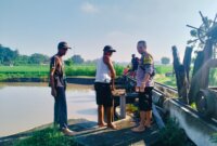Bhabinkamtibmas Polsek Warujayeng buka saluran dam bersama perangkat desa