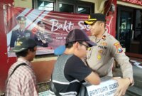 Kapolsek Asemrowo Kompol Rahardian B. Trisna saat bagi paket sembako