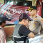 Kapolsek Asemrowo Kompol Rahardian B. Trisna saat bagi paket sembako