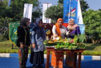 Kaper BKKBN Jatim Maria Ernawati saat potong tumpeng di momen Harganas ke-32