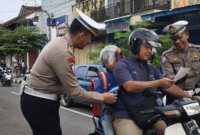 Kasatlantas Polres Ponorogo AKP Bayu Pratama Sudirno beri cinderamata pengguna jalan