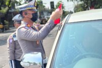 Kasatlantas Polres Nganjuk AKP Ivan Danara Oktavian bagikan bendera Merah Putih