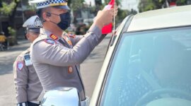 Kasatlantas Polres Nganjuk AKP Ivan Danara Oktavian bagikan bendera Merah Putih