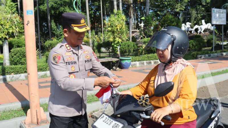 Wakapolresta Banyuwangi AKBP Teguh Priyo Wasono bagi bendera merah putih