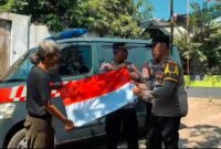 Polisi bagi bendera merah putih ke warga