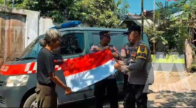 Polisi bagi bendera merah putih ke warga