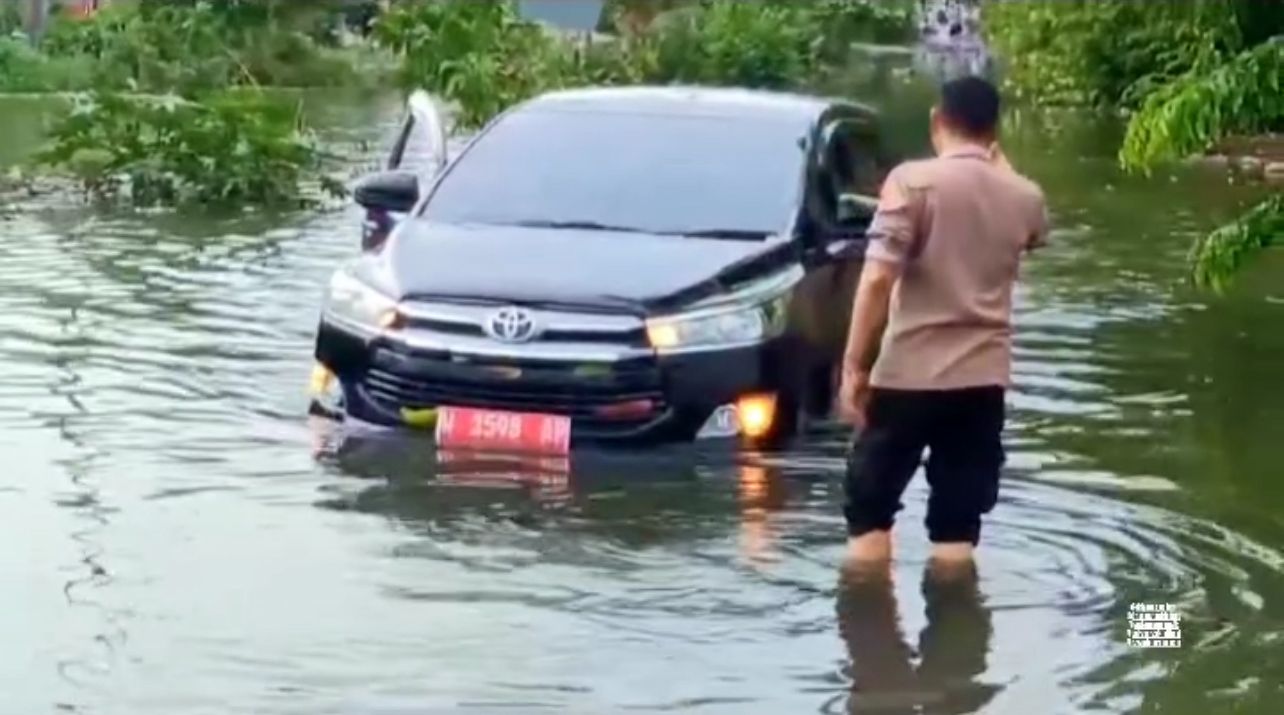 Polisi bersama warga bantu kendaraan terjebak banjir
